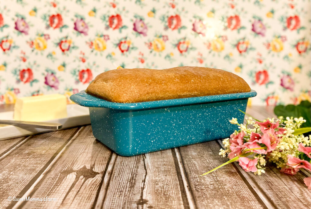 Homemade bread in a blue tin with butter on the side