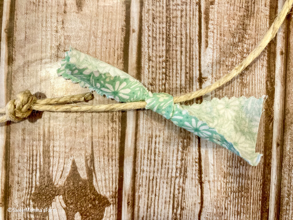 Strip of green fabric tied on to jute string easter banner