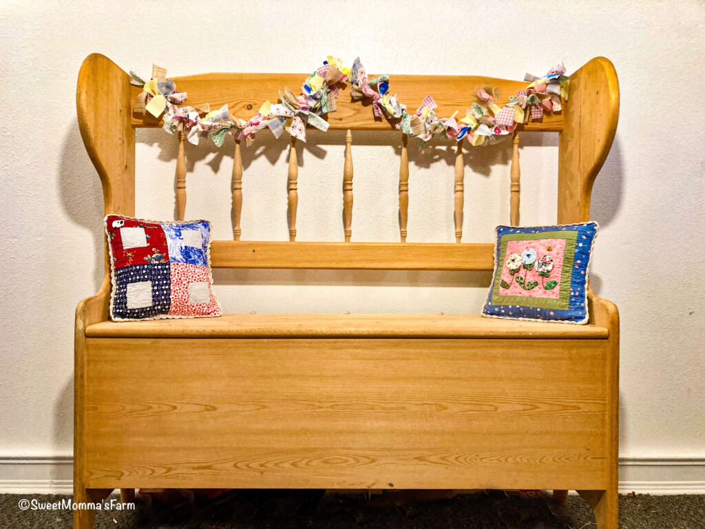 A wood decans bench with a easter fabric stip banner across the top.
