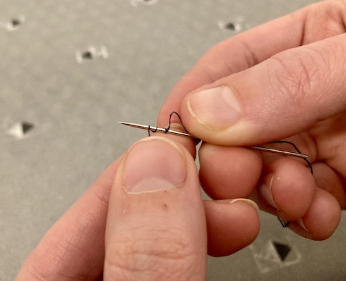 Third weave to marrying the needle and thread by weaving the needle into the thread.