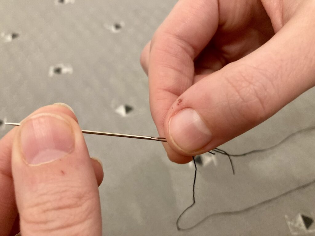 Pulling the three wraps of the thread down to the end of the needle