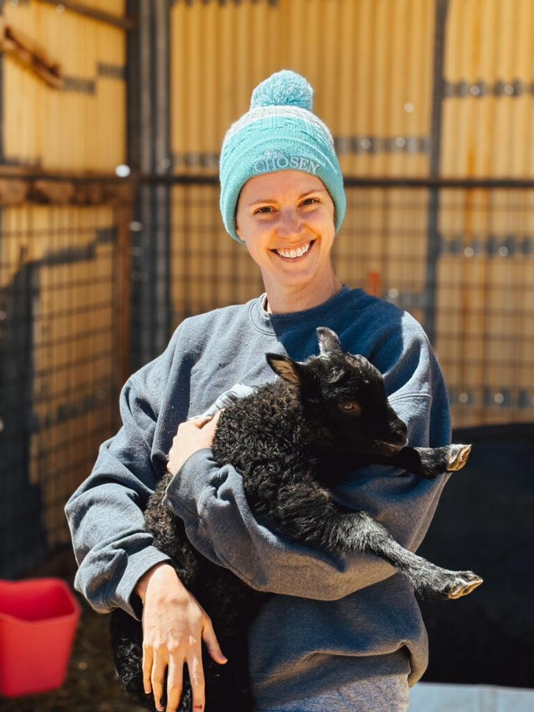 faith-based homesteading with a lady holding a lamb
