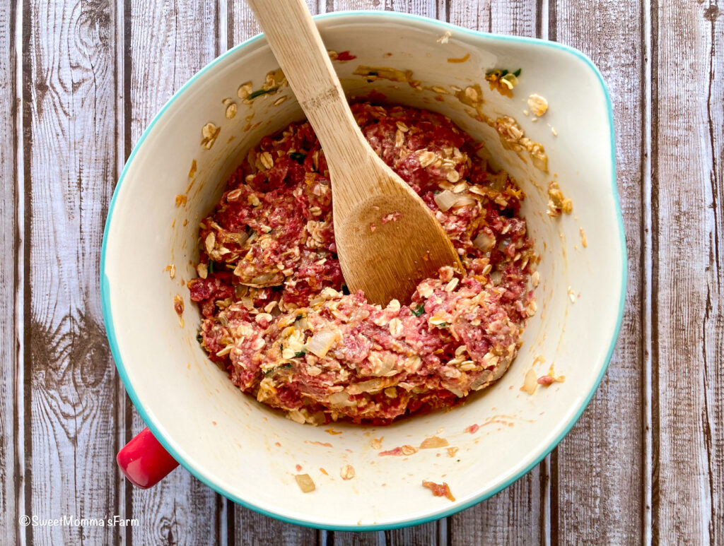 Raw meatloaf mixture in a bowl with a spoon