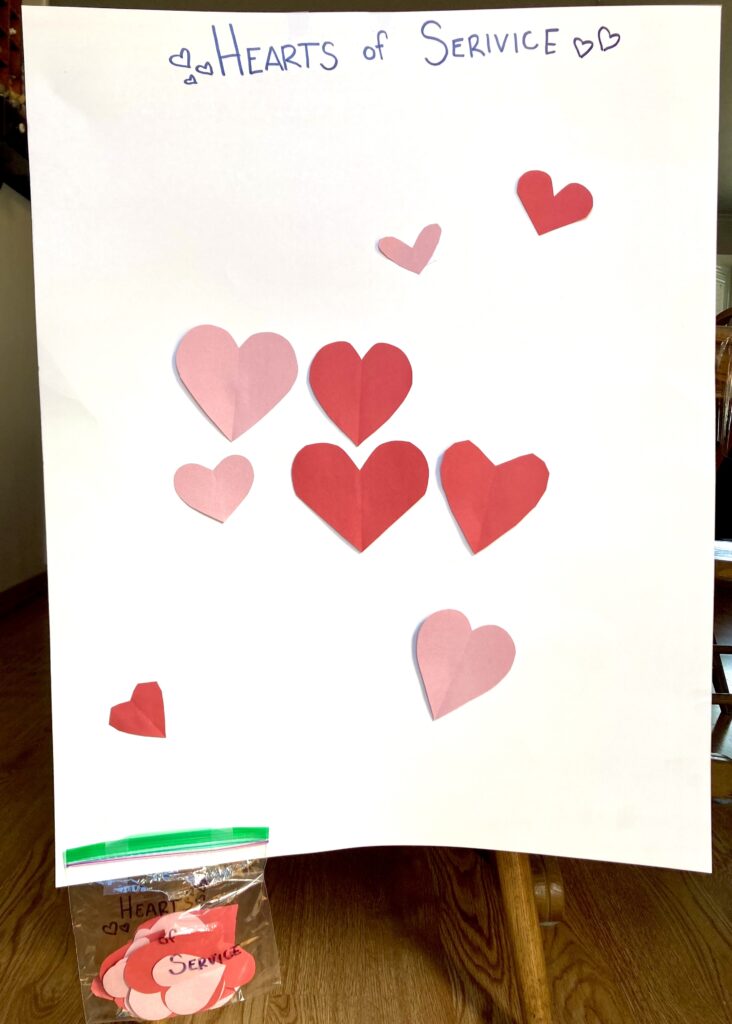 Hearts of Service Board with a bag of hearts attached to the bottom