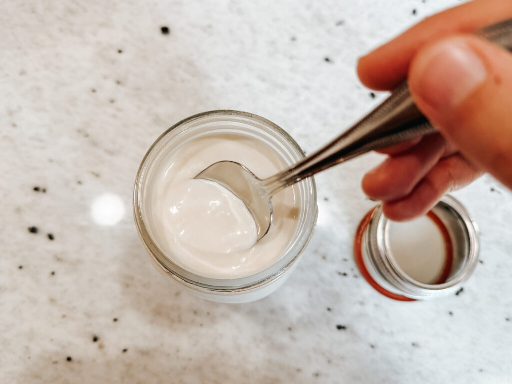 A spoon cutting into fresh clabber