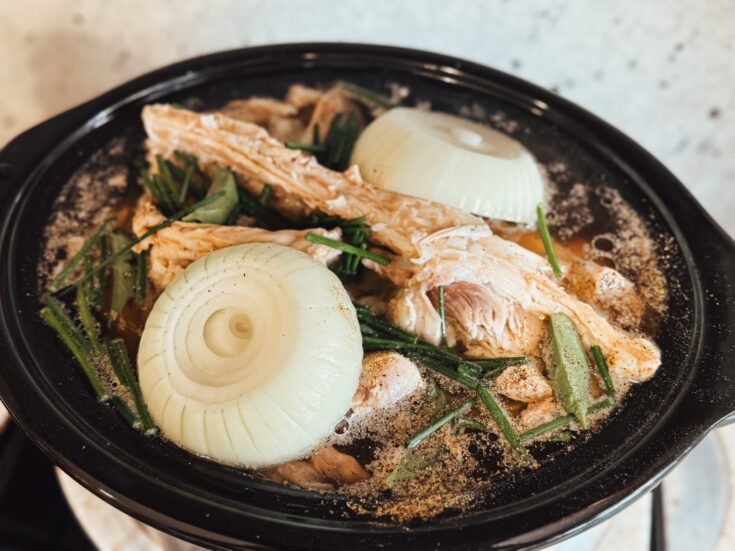 Both Broth with onion, herbs and peppercorn simmering in a crockpot